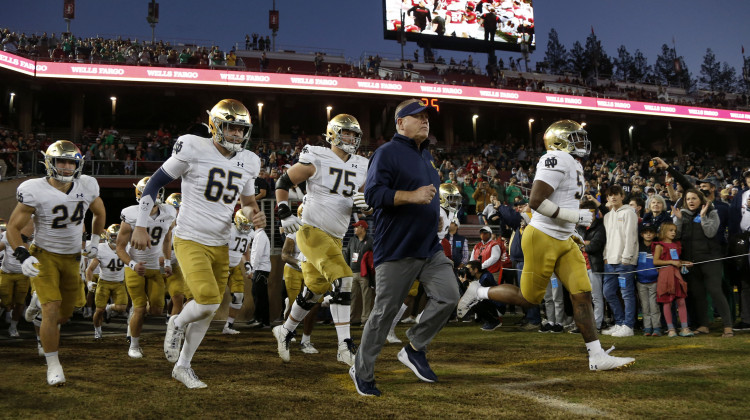 Notre Dame coach Brian Kelly, center, runs onto the field for the team's NCAA college football game against Stanford in Stanford, Calif., Saturday, Nov. 27, 2021. - (AP Photo / Jed Jacobsohn)