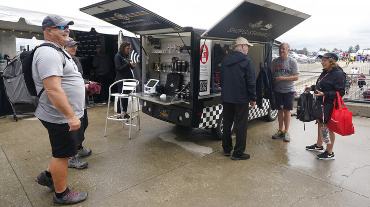 Race fans look at shirts that are made from plastic bottles during the final practice for the Indianapolis 500 auto race at Indianapolis Motor Speedway, Friday, May 27, 2022, in Indianapolis. - AP Photo/Darron Cummings