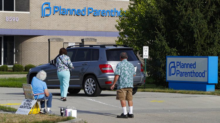 FILE - Abortion protesters attempt to hand out literature as they stand in the driveway of a Planned Parenthood clinic in Indianapolis, Aug. 16, 2019. Hospitals and abortion clinics in Indiana are preparing for the state's abortion ban to go into effect on Sept. 15, 2022.  - AP Photo/Michael Conroy, File