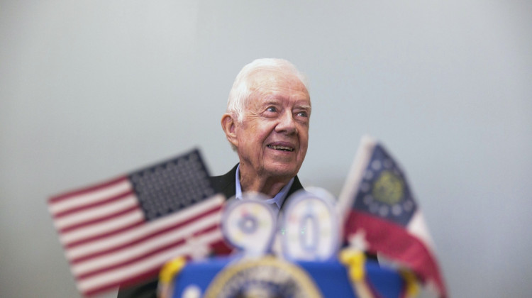 Former President Jimmy Carter stands behind his birthday cake during his 90th birthday celebration held at Georgia Southwestern University, Oct. 4, 2014, in Americus, Ga. (AP Photo/Branden Camp, File)