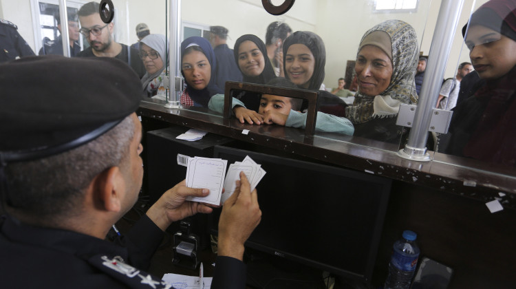Palestinians with dual nationality register to cross to Egypt on the Gaza Strip side of the border crossing in Rafah on Thursday. - Hatem Ali / AP