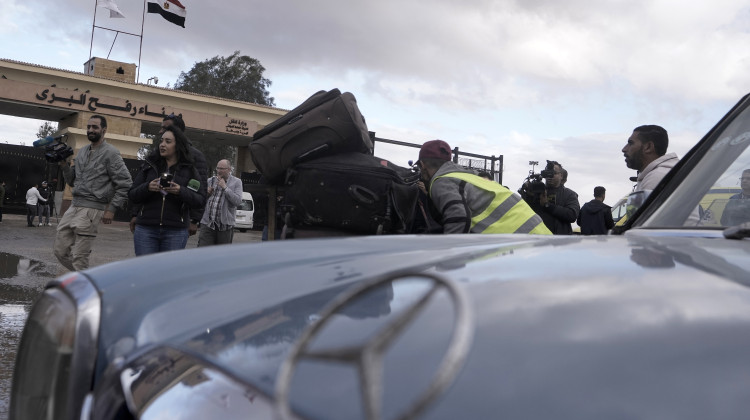 A worker pushes a trolly with luggage of Palestinians stranded in Egypt as they wait to cross the Rafah border crossing to the Gaza Strip, at Rafah, Egypt, during a temporary ceasefire, Monday, Nov. 27, 2023. - (AP Photo/Amr Nabil)