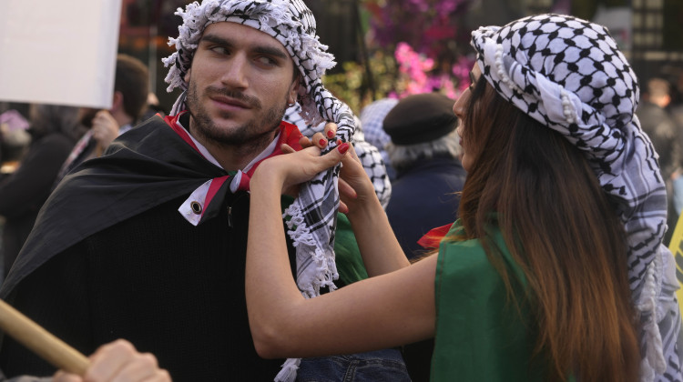Two people wear Palestinian keffiyehs, during a Pro-Palestinian demonstration march in Madrid, Spain, Saturday, Dec. 2, 2023. Israel pounded targets in the southern Gaza Strip on Saturday, intensifying a renewed offensive that followed a weeklong truce with Hamas and giving rise to renewed concerns about civilian casualties. (AP Photo/Paul White)