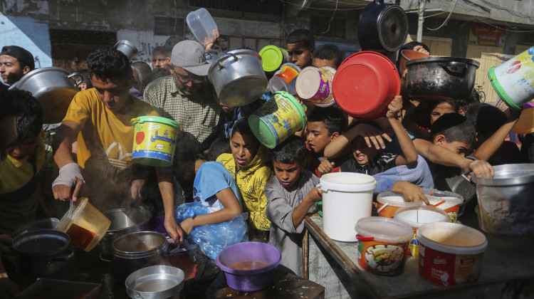 FILE - Palestinians crowd together as they wait for food distribution in Rafah, southern Gaza Strip, Nov. 8, 2023. Catastrophic hunger is so dire in two world hotspots that famine is imminent in northern Gaza and approaching in Haiti, with hundreds of thousands of people in both places struggling to avoid starvation, according to international food security experts and aid groups.  - (AP Photo/Hatem Ali, File)