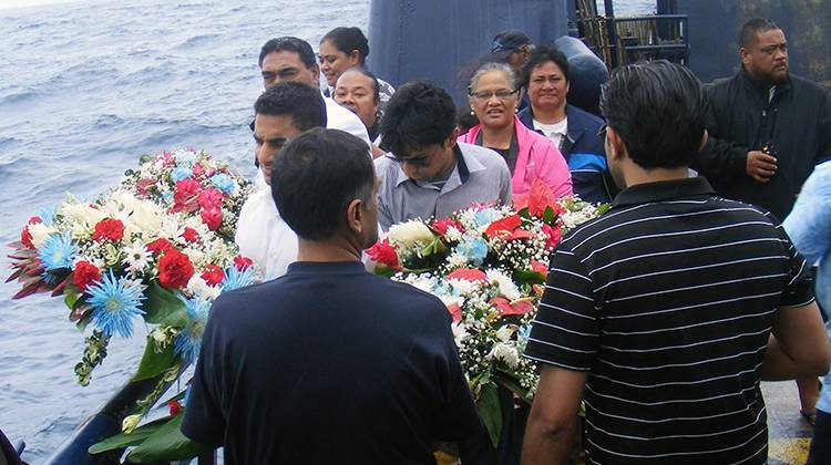 Two members of the Suleman family prepare to lay the wreaths during a memorial service honoring Haris Suleman who died and his father, Babar Suleman,  who is missing after their plane crashed during an attempt to circumnavigate the world. - AP Photo/Fili Sagapolutele