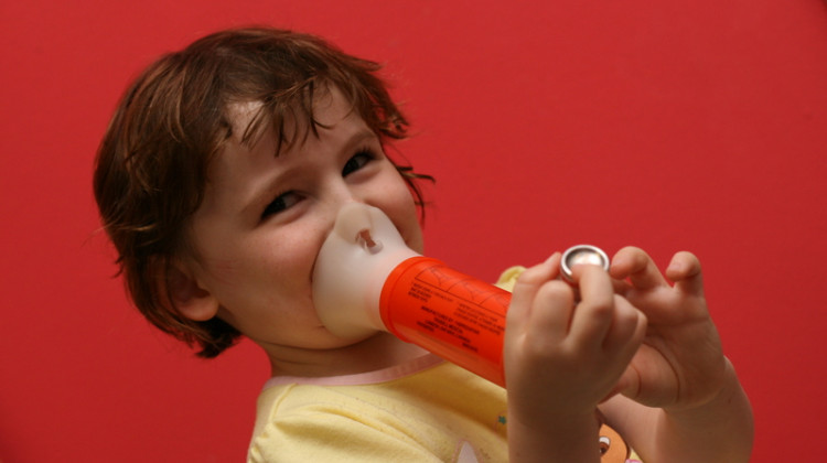 A child uses a spacer with an inhaler to treat asthma symptoms. Rising temperatures make the ozone and particle pollution that contribute to asthma problems worse. - Wikimedia Commons