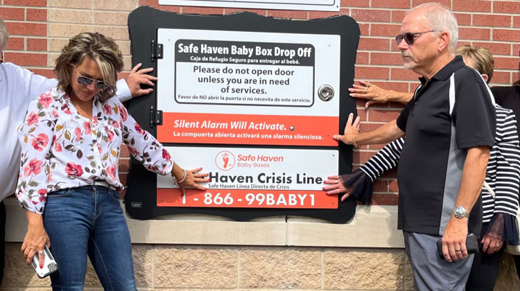 Monica Kelsey (left) joined city officials and residents in Elwood, Indiana, in July to say a blessing over the citys new baby box, a place where newborns can be anonymously surrendered. - Jill Sheridan / WFYI