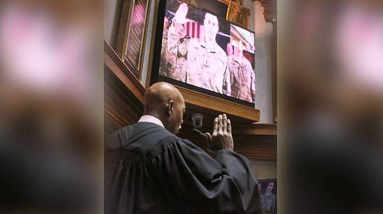 Indiana Supreme Court Justice Robert Rucker administers the oath of office to Sen. Jim Banks, R-Columbia City, who was video-conferencing in from Afghanistan. - Photo by Lesley Weidenbener, TheStatehouseFile.com