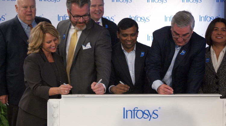 State and local officials along with Infosys company leaders sign a beam commemorating the progress to its U.S. Educational Center in Indianapolis.  - Samantha Horton/IPB News