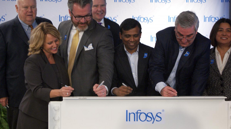 State and local officials along with Infosys company leaders sign a beam commemorating the progress to its U.S. Educational Center in Indianapolis. - Samantha Horton/IPB News