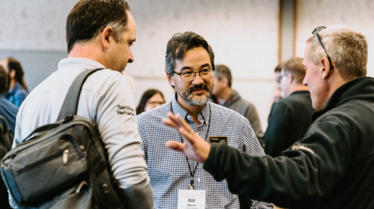 Purdue University Professor William Watson (center) speaks with attendees at the university’s inaugural AI in P-12 Education conference on Nov. 11, 2024. - A. Ott / Purdue University