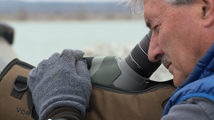 Jim Hengeveld uses a telescopic lens to count loons and other birds on Lake Monroe. - Steve Burns/WTIU