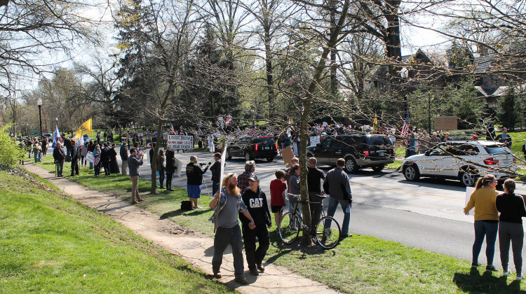 Protesters lined the street in front of the governor’s mansion waving American flags and holding signs as supporters honked in passing. - Lauren Chapman/IPB News
