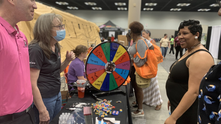 Health fair attendees in 2021 at a booth that was raising awareness about HIV testing and prevention and giving away prizes such as bags, water bottles and condoms.  - Farah Yousry/WFYI