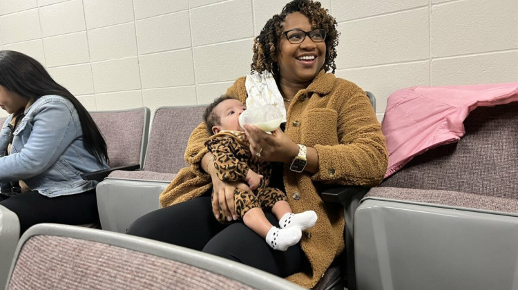 Latasha Girdy feeds her 3-month-old daughter Mikayla during the panel discussion. - Jade Jackson/Indianapolis Recorder