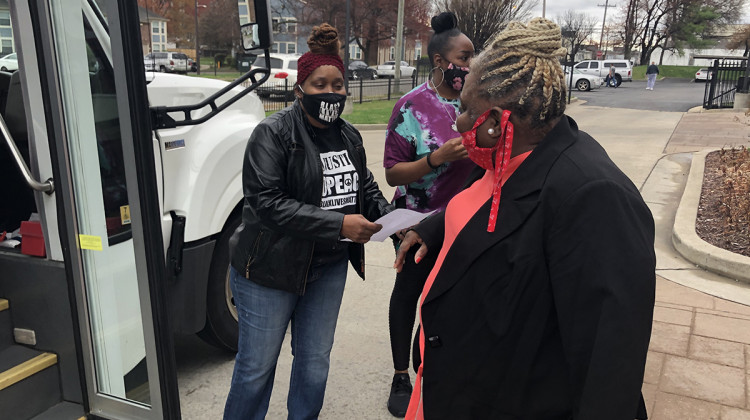 Harriett Rankin, a member of Black Lives Matter Louisville, helps residents board a van to get their second dose of the COVID-19 vaccine. - Jess Clark/WFPL