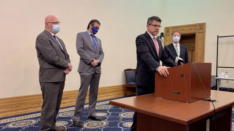 Senate President Pro Tem Rodric Bray (R-Martinsville) speaks at a lectern about the latest revenue forecast. Behind him, from left, Rep. Tim Brown (R-Crawfordsville), Sen. Ryan Mishler (R-Bremen) and House Speaker Todd Huston (R-Fishers).  - Brandon Smith/IPB News