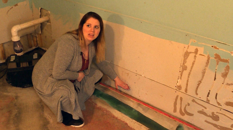 Bartholomew County resident Amanda Burdine shows where the water line was in her basement during this February's flooding. - Sean Hogan/WTIU