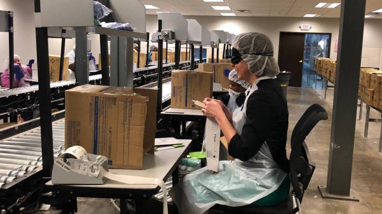 State Treasurer Kelly Mitchell wears a sleep shade as she's trained on a Bosma Enterprises assembly line to pack gloves. - Catherine Seat/Indiana Treasurer of State