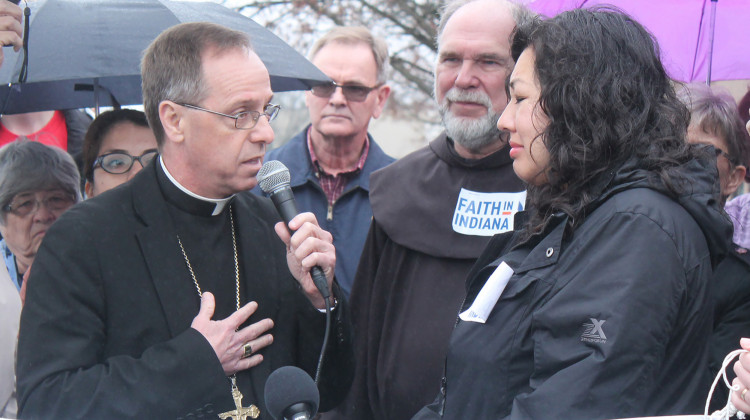 Catholic Archbishop Charles Thompson offers a prayer before he, Father Larry Janezic, and Erika Fierro go inside the immigration office.  - Lauren Chapman/IPB News
