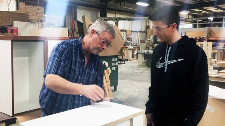 Caleb Pierson looks over a cabinet project he designed for Heartwood Manufacturing. Pierson is a graduate of a program run through Batesville High School, that helps students get manufacturing skills while still in high school. - Claire McInerny/IPB