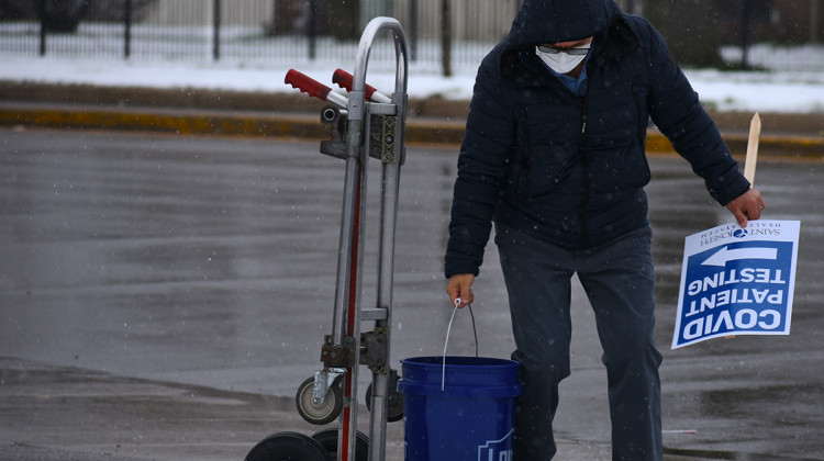 A health care worker at the Sister Maura Brannick CSC Health Center in South Bend puts out a sign directing people where to get tested for COVID-19.  - Justin Hicks/IPB News