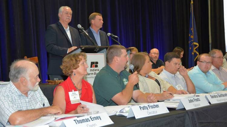 John Feutz, Indiana Farm Bureau county president of Gibson County, speaks to the member delegates. In the background are INFB President Randy Kron (left) and INFB Vice President Kendell Culp (right).  - Courtesy IFB