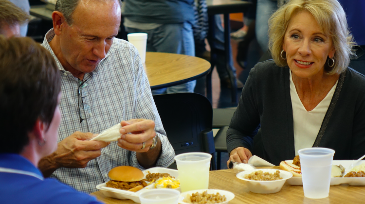 U.S. Education Secretary Betsy DeVos and husband Dick eat at the Eastern Hancock High School cafeteria for the annual FFA hog roast fundraiser on Friday, Sept. 15, 2017 during the last stop on the â€œRethink Schoolâ€ tour.  - Eric Weddle/WFYI Public Media