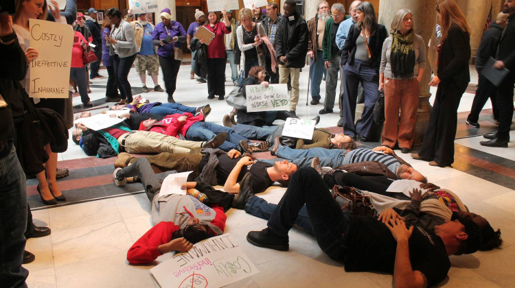During a 2018 demonstration, protesters gather in front of Gov. Eric Holcomb's office as part of a "die in." The group demanded Holcomb veto a law that increased penalties for a drug dealer if a person overdosed and died. It was signed into law four days later.  - Lauren Chapman/IPB News