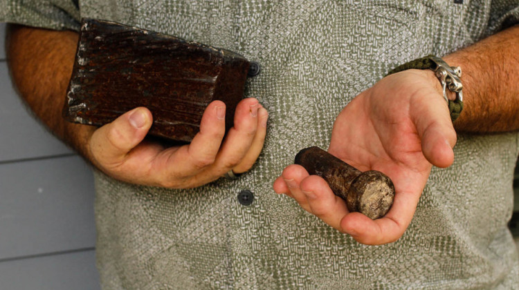 Joe Dittmar holds remnants of the World Trade Center â€” a section from one of the core beams of the South Tower, right, and a bolt from a steel beam. - Jud Esty-Kendall/StoryCorps