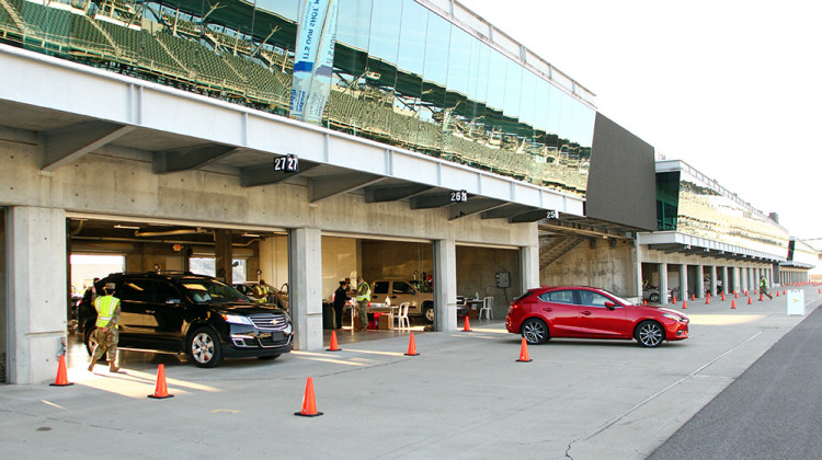 Vehicles leave the garage area after occupants received their COVID-19 vaccination during the first mass vaccination clinic at the Indianapolis Motor Speedway on March 5. - Doug Jaggers/WFYI