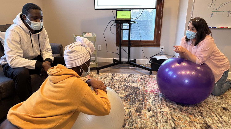 At a childbirth class in late January, Doula Kristi Pietz, right, shows Kaosarat Aina and her husband Ibrahim Odugbemi a position on a yoga ball that could make labor more comfortable. - Lauren Bavis / Side Effects Public Media