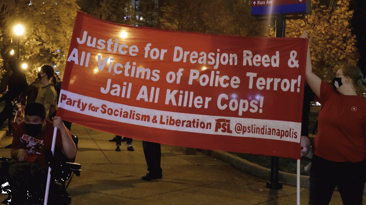 Protesters hold a sign at University Park following a grand jury's decision not to indict an Indianapolis police officer for the May shooting death of 21-year-old Dreasjon Reed. - Eric Weddle/WFYI News