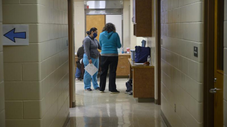 Tama County Public Health Executive Director Shannon Zoffka (right) speaks to a volunteer at the county's COVID-19 vaccination clinic at the former Girls State Training School in Toledo, Iowa. - Natalie Krebs/Side Effects Public Media