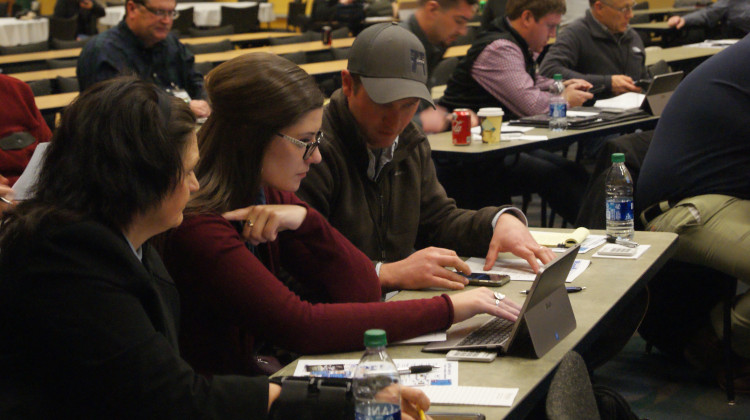 (Left to right) Kayla Holscher, Jenna Lansing and Andy Hruby work as a group during the Ag Survivor simulator activity at Purdue University's Top Farmer Conference. - Samantha Horton/IPB News