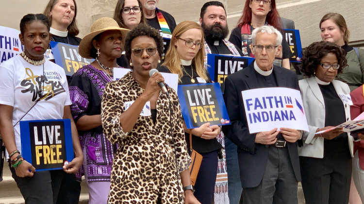 Shonda Nicole Gladden, holding the microphone, speaks on the Indiana Statehouse steps with members of Faith in Indiana.  - Brandon Smith/IPB News