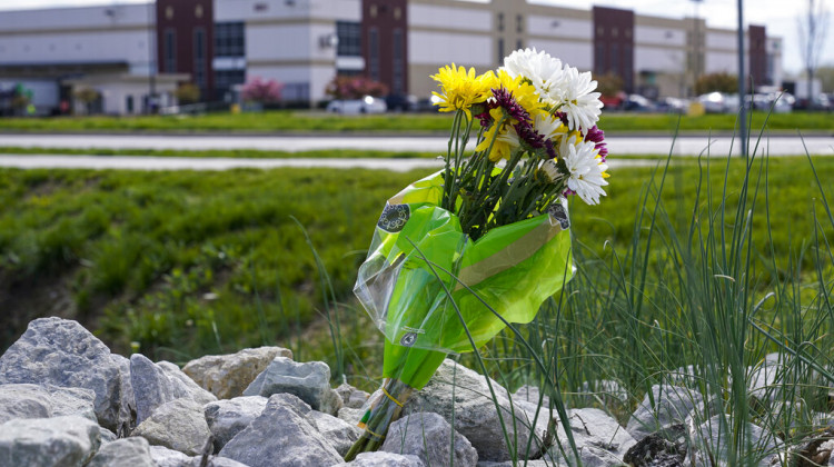 A single bouquet of flower sits in the rocks across the street from the FedEx facility in Indianapolis, Saturday, April 17, 2021 where eight people were shot and killed. - Michael Conroy/AP Photo