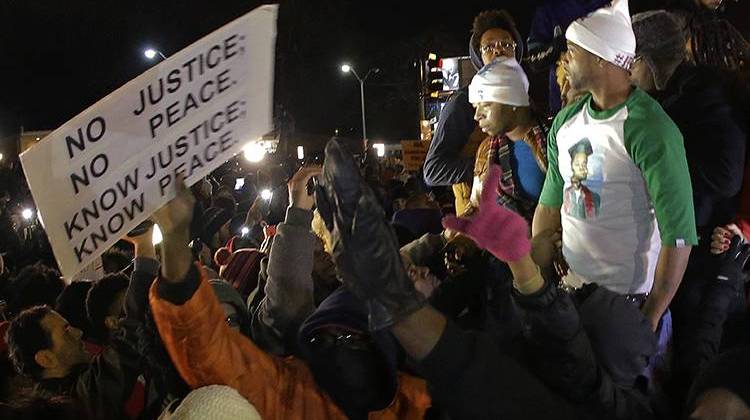 Lesley McSpadden, the mother of Michael Brown, left standing on the top of a car, reacts as she listens to the announcement of the grand jury decision Monday, Nov. 24, 2014, in Ferguson, Mo. A grand jury has decided not to indict Ferguson police officer Darren Wilson in the death of Michael Brown, the unarmed, black 18-year-old whose fatal shooting sparked sometimes violent protests. - AP Photo/Charlie Riedel