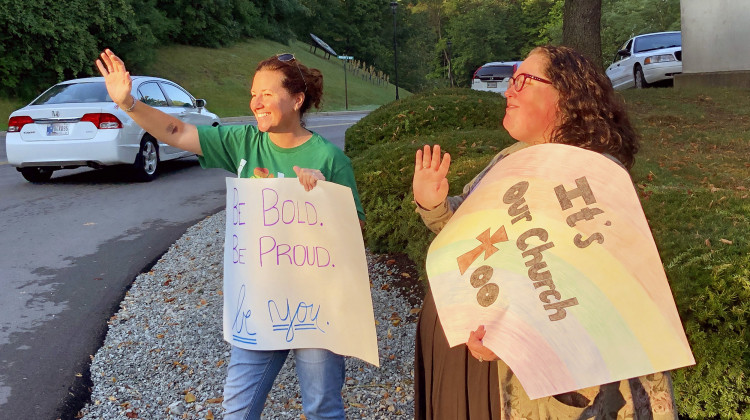 Shelly Fitzgerald waves to students entering Cathedral High School's campus. Fitzgerald was a guidance counselor at Roncalli High School before being put on administrative leave last year due to her same-sex marriage. - Darian Benson/WFYI