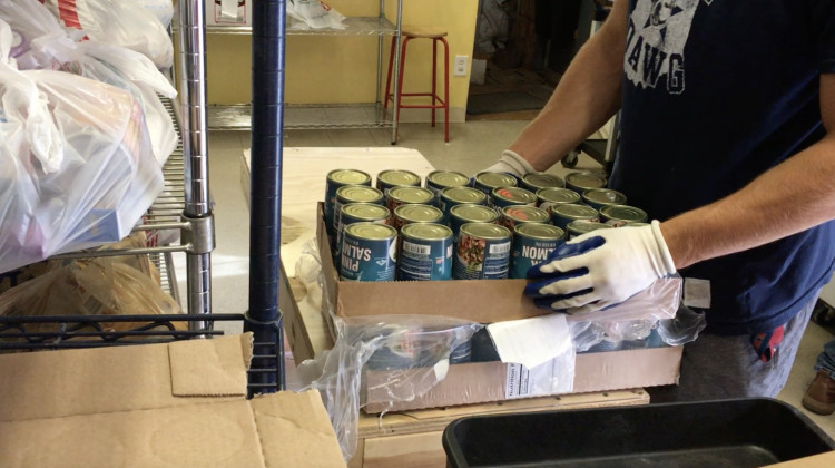 Volunteer shelves canned goods at the St. Vincent de Paul Food Pantry - Courtesy of St. Vincent de Paul Food Pantry
