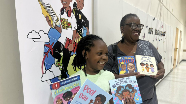 8-year-old Zariah Thomas and her grandmother Lilian Henderson posing with their free books from Black WorldSchooler Mobile Bookstore  - Photo/Jade Jackson