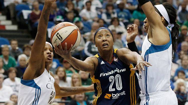 Indiana Feverâ€™s Briann January, center, attempts a layup between Minnesota Lynxâ€™s Rebekkah Brunson, left, and Maya Moore, right, in the first half of Game 1 of the WNBA basketball finals Sunday, in Minneapolis. - AP Photo/Jim Mone