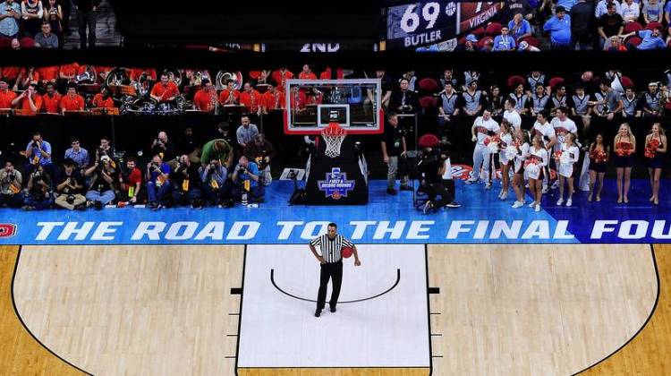 An official, photographers, cheerleaders and others wait for play to resume during an NCAA Men's Basketball Tournament second-round game between the Butler Bulldogs and the Virginia Cavaliers in March in Raleigh, N.C. This coming spring the Road to the Final Four won't go through North Carolina, as the NCAA has decided to move three games out of Greensboro.