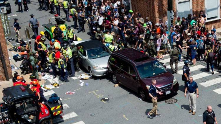 People receive first aid after a car ran into a crowd of protesters in Charlottesville, Va., on Saturday. The car struck the silver vehicle pictured, sending marchers into the air.
