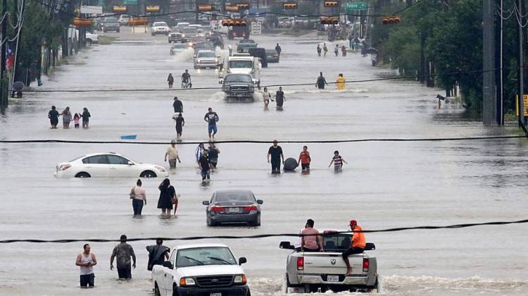 People walk through floodwaters on Telephone Road in Houston on Sunday after 2 feet of rain from Hurricane Harvey pummeled the Gulf Coast. - Thomas B. Shea/AFP/Getty Images