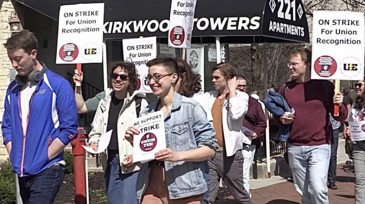 IU graduate student workers march with signs about an upcoming strike to advocate for a workers' union.