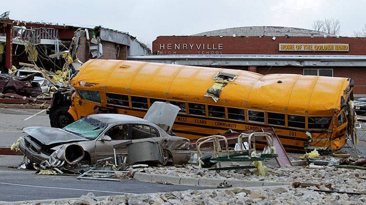 FILE - In a March 3, 2012, file photo vehicles damaged by a tornado lie in the parking lot of the Henryville Jr./Sr. High School in Henryville, Ind. - AP Photo/Michael Conroy