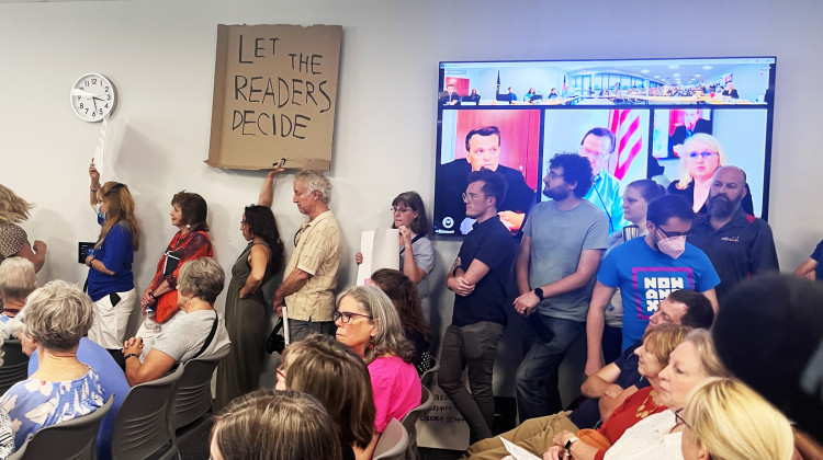 More than 120 people packed into a meeting of the Hamilton East Public Library Board on Thursday, Aug. 24, 2023 at the Noblesville branch. A video screen shows a live feed of the meeting. The board voted to suspend a controversial collection development policy. - Lee Gaines / WFYI