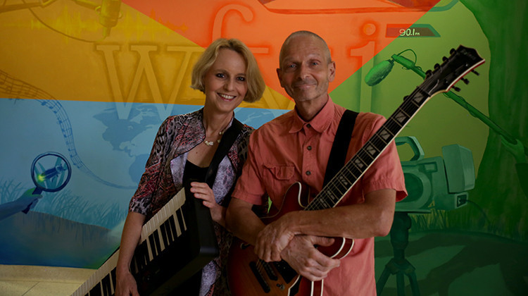 Pianist Monika Herzig and guitarist Peter Kienle in front of a mural painted inside WFYI headquarters.