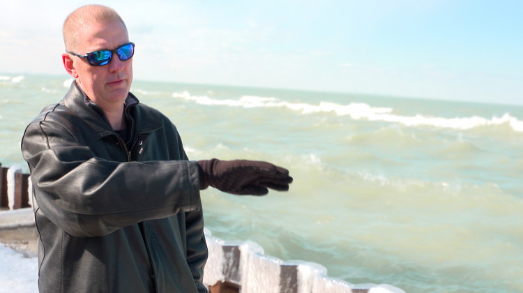 Ogden Dunes resident Rodger Howell says because there's no stone toe protection in front of seawalls along part of the town's shore, waves crash over those walls and wash the sand out behind them.  - Alan Mbathi/IPB News